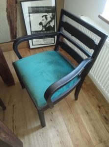 Mit grünem Samt bezogener restaurierter Stuhl mit Armlehnen.